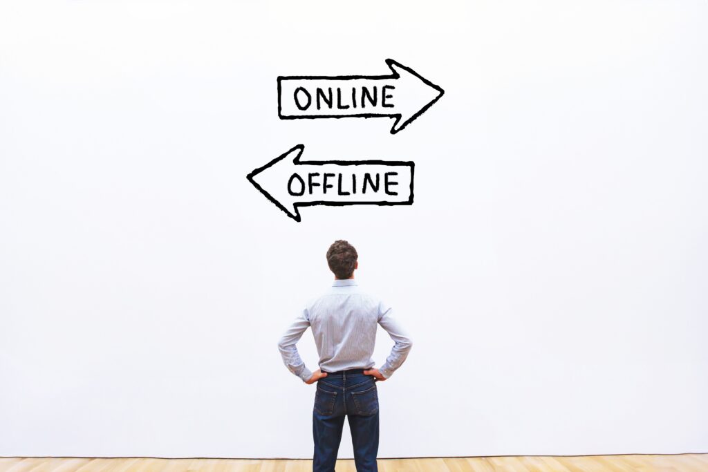 A man looking at a wall with two arrows in opposite directions comparing online and offline direct marketing
