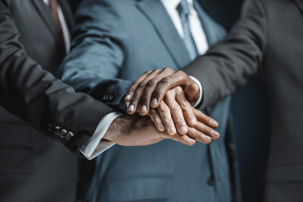 Business professionals holding hands together as a sign of business partnership.