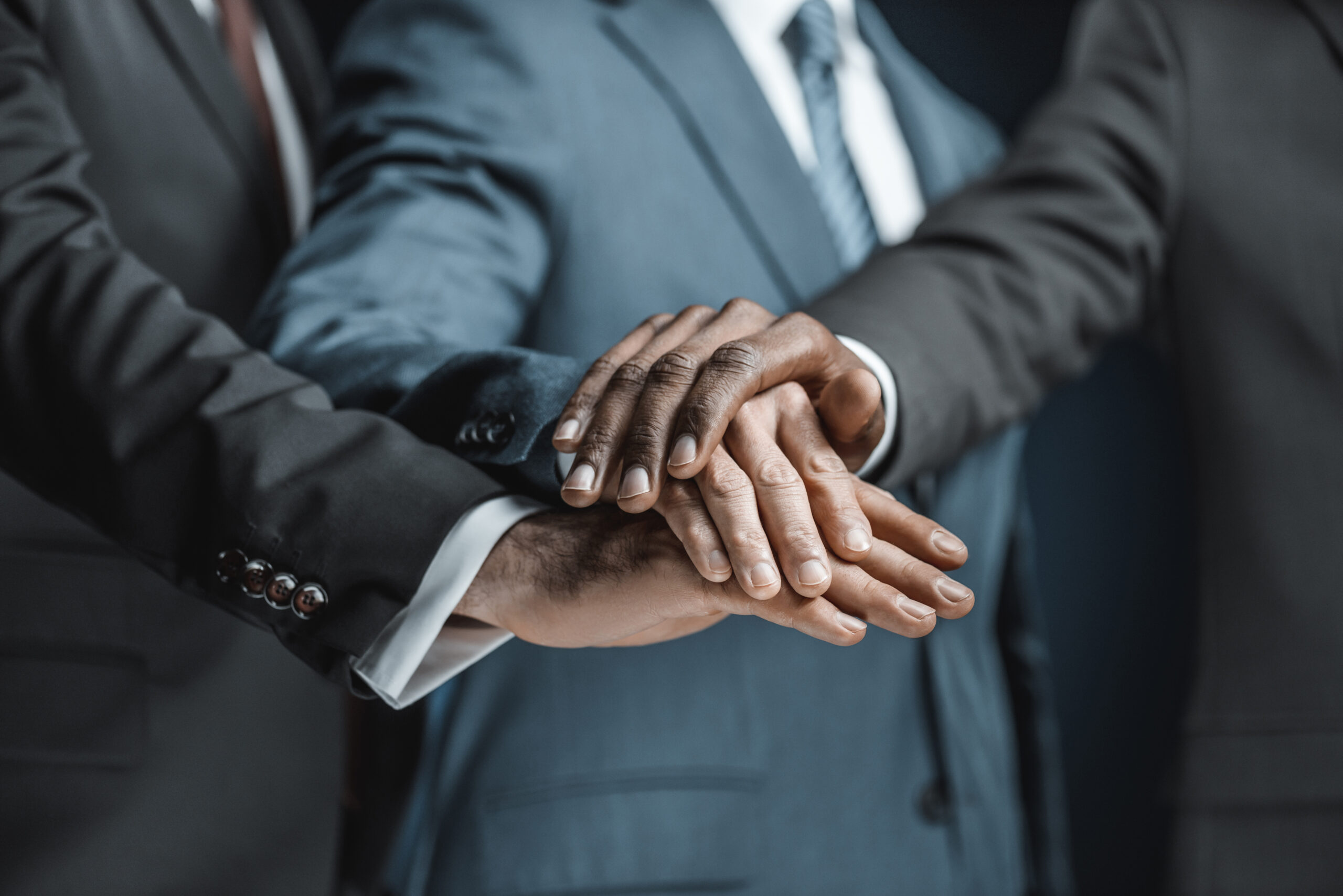 Business professionals holding hands together as a sign of business partnership.